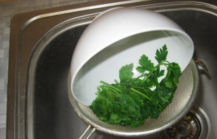 1. Этап. Фарш для пельменей: Закидываем зелень в миску и заливаем ее крутым кипятком из чайника, даем постоять зелени в кипятке минуту, после чего откидываем петрушку на дуршлаг и даем стечь воде.