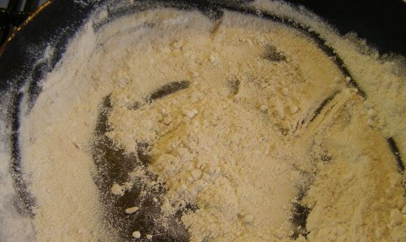 1. Этап. Мясо, тушенное в сметане: Возьмите чистую и сухую сковородку с антипригарным покрытием, разогрейте её на слабом огне. Высыпьте на сковороду муку, обжаривайте её до золотистого цвета, постоянно помешивая.