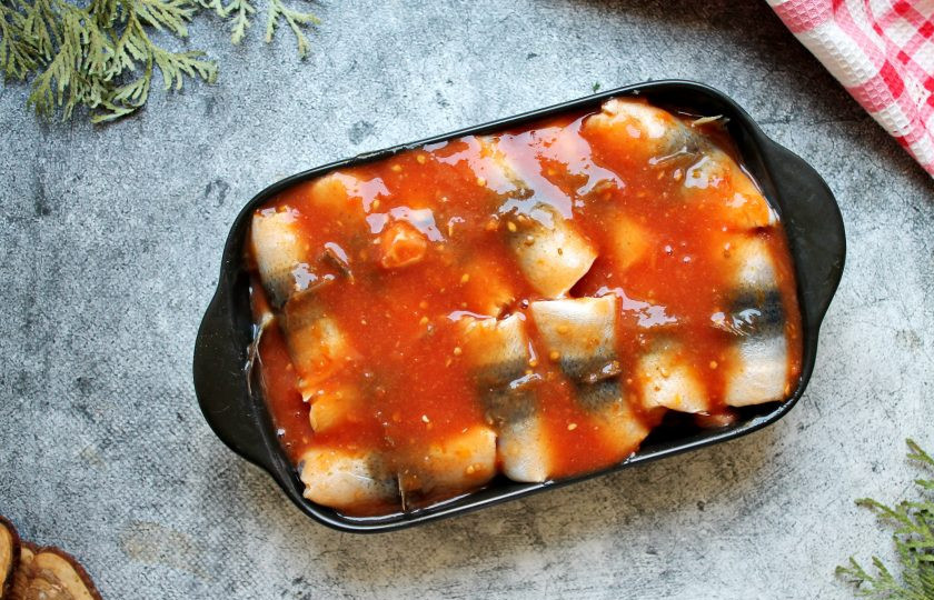 1. Этап. Салака в томате: Томатный сок посолите, поперчите и перемешайте. Залейте томатным соком рулетики из сайры.