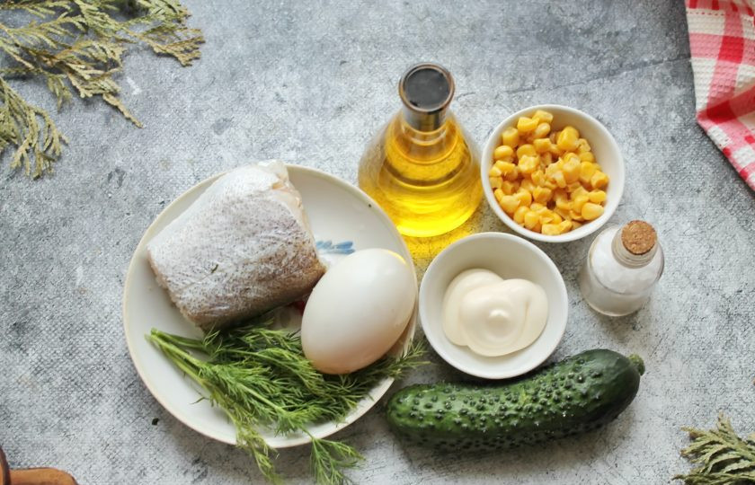 1. Этап. Салат с треской и кукурузой: Подготовьте все необходимые ингредиенты для приготовления салата с треской и кукурузой. Кукурузу откиньте на сито и дайте жидкости стечь, а зелень и огурец вымойте и обсушите. Треску (филе) выложите в кастрюлю, залейте холодной водой и посолите. Варите рыбу в течение 15-20 минут после закипания. Спустя время треску извлеките из бульона и остудите.