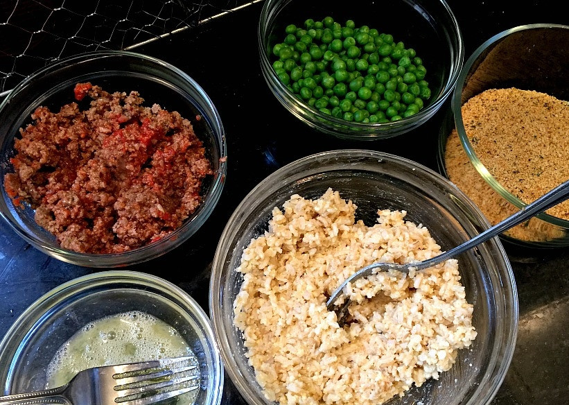 1. Этап. Рисовые колобки с мясом: 1. Фарш смешайте с 1 желтком, 2 стаканам тертого сыра, измельченным луком и чесноком, 1 стаканом панировочных сухарей, обжарьте его до готовности. Отварной рис смешайте с 1 желтком и оставшимся тертым сыром. Смешайте 2 куриных белка, в отдельную емкость выложите молодой зеленый горошек и панировочные сухари.