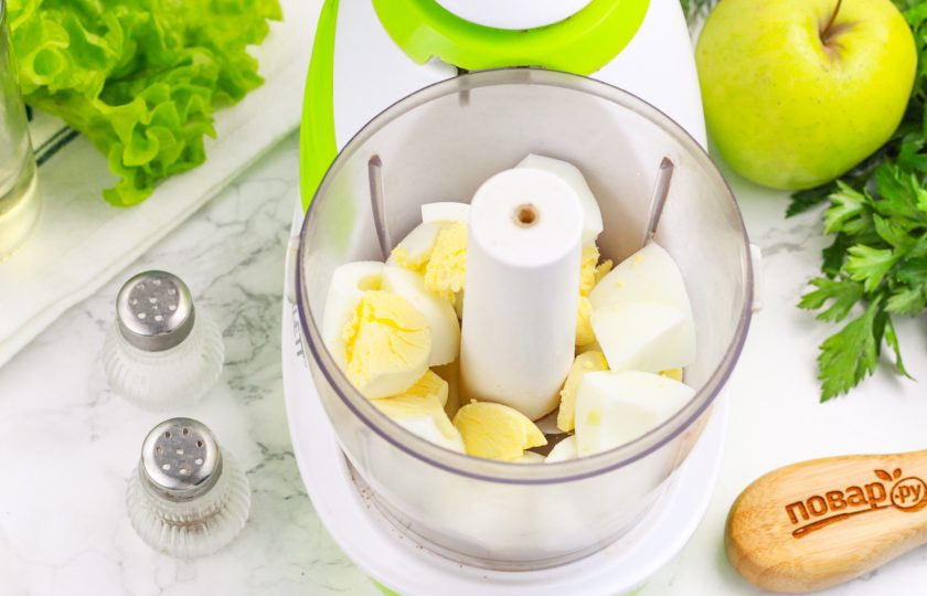 1. Этап. Форшмак из мойвы: Отварные куриные яйца очистите от скорлупы и промойте в воде. Нарежьте на части и выложите нарезку в емкость блендера или измельчителя.