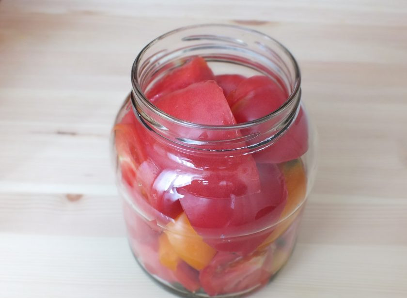 1. Этап. Помидоры резаные на зиму: Уложите плотно четвертинки помидоров.