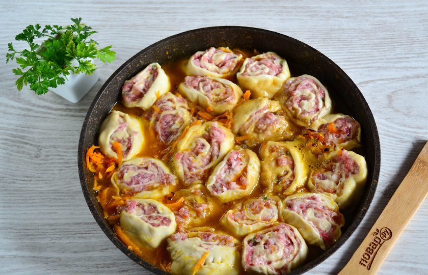 1. Этап. Ленивые пельмени на сковороде: Снова поставьте сковороду на огонь, поверх морковиплотно друг возле друга выложите пельмени-рулетики. Добавьте воды, чтобы заполняла примерно половину сковороды.