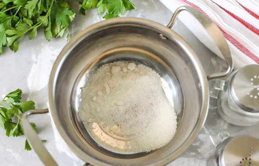 1. Этап. Маринованный лук кольцами на зиму: В кастрюлю всыпьте соль и сахарный песок.