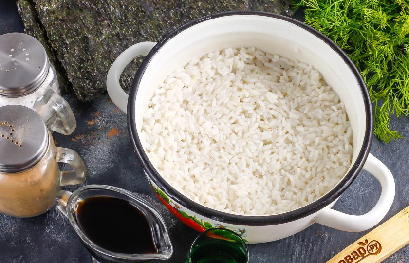 1. Этап. Спайси роллы: Рис промойте в воде, высыпьте в кастрюлю или казан с кипящей водой, добавьте туда же 2 щепотки соли и отварите на умеренном нагреве примерно 12-15 минут. Затем прогрейте рисовый уксус в микроволновке или в емкости, всыпьте в него сахар и перемешайте. Влейте уксус в рис и перемешайте, накройте крышкой и оставьте на 10 минут для пропаривания. Можно вместо крышки использовать марлевое полотно или тонкое полотенце.