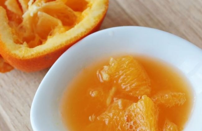 1. Этап. Салат с гранатом и орехами: Апельсин вымойте и обсушите. Разрежьте его на две равных половины и ложкой достаньте мякоть, собрав ее и сок в пиалку.