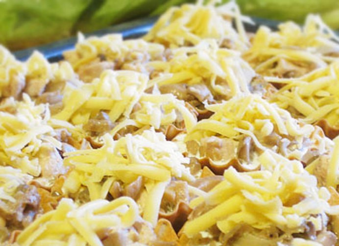 1. Этап. Тарталетки с курицей и грибами: Залейте в каждую корзинку немного сливок и посыпьте сверху тертым сыром. Отправьте противень с тарталетками в духовку на 15 минут при 200 градусах.