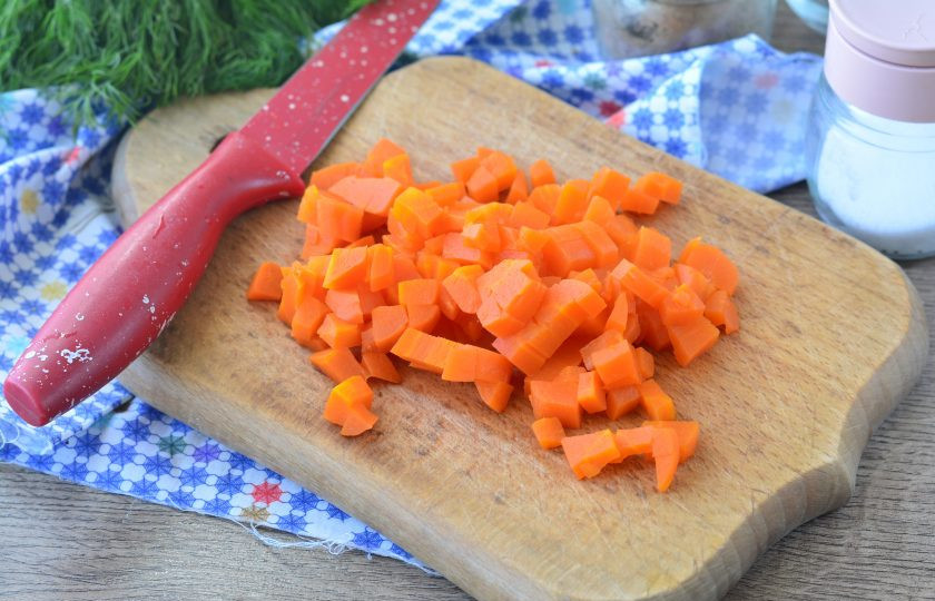 1. Этап. Салат с бужениной и кукурузой: Нарежьте кубиками сваренную морковку.