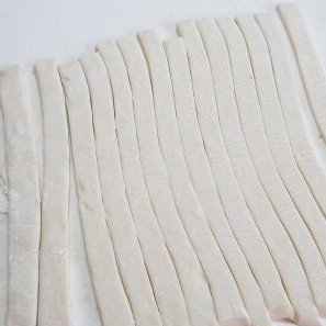 1. Этап. Печенье с ананасами: Тесто раскатываем в тонкий (около 5 мм) пласт и разрезаем на полоски шириной около 1 см.