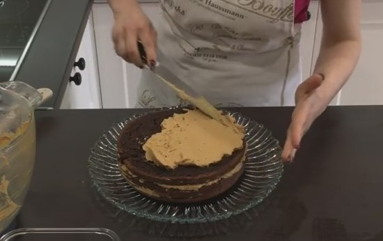 1. Этап. Домашний шоколадный торт Пеле: 9. Выложите крем на корж. Распределите его таким образом, чтобы толщина крема составляла половину от толщины коржа. Соберите торт, сверху тоже смажьте кремом, затяните края.