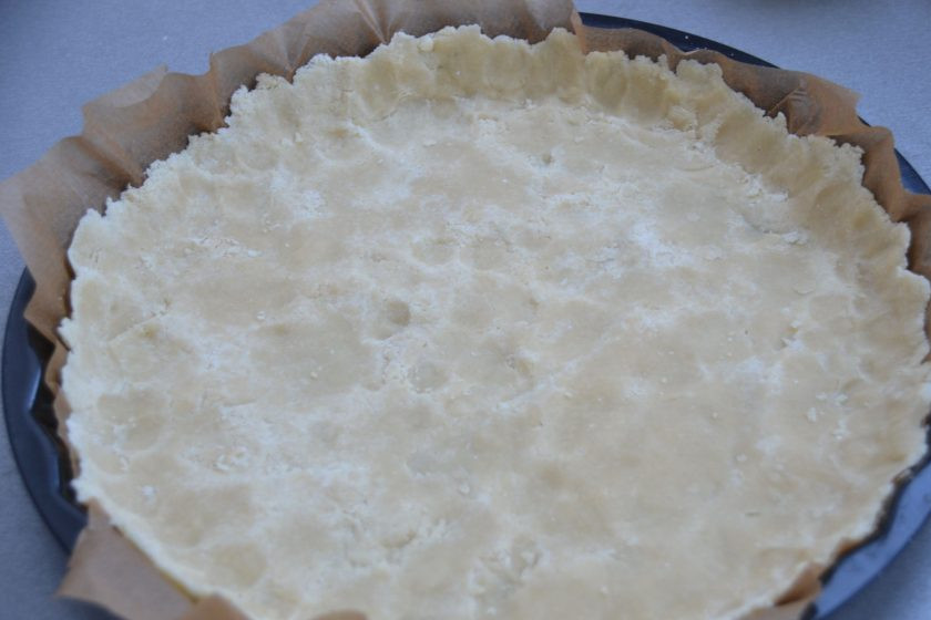 1. Этап. Пирог с грушей и сыром: Застелите дно формы с невысокими бортиками пекарской бумагой, так, чтобы ее края выступали (потом будет легче извлечь пирог). Высыпьте масляно-мучную смесь, руками сформуйте дно и бортики будущего пирога. Уберите в холодильник на время приготовления начинки.