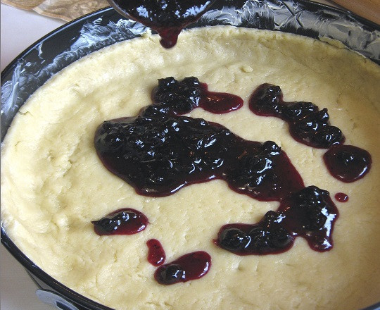 1. Этап. Пирог на маргарине с вареньем: 6. Вторую часть распределить в жаропрочной форме, смазанной маслом или застеленной пергаментом. Сверху выложить любое варенье, которое есть под рукой. Предпочтение лучше отдать более густому.