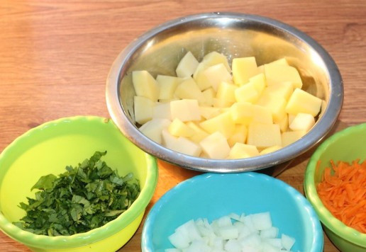 1. Этап. Cуп из куриных шеек с рисом: 3. Зелёный лук и петрушку мелко порубить ножом. Лук, морковь и картофель очистить. Картофель нарезать небольшими кубиками.