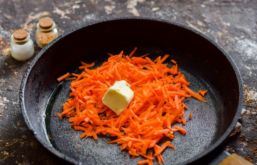 1. Этап. Морковные котлеты с творогом: Морковь очистите и сполосните, натрите на терке. Переложите морковь в сковороду, добавьте кусочек сливочного масла. Тушите морковь 3-4 минуты.