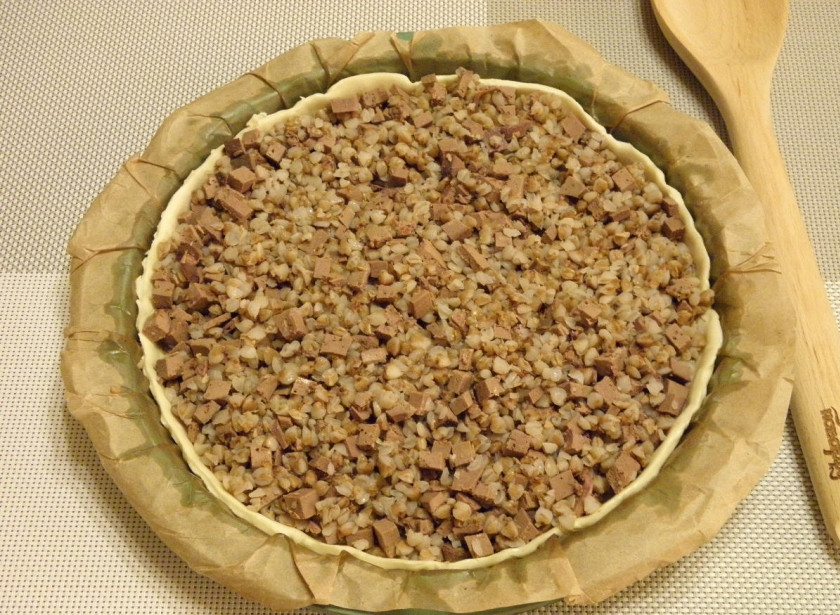 1. Этап. Пирог с гречкой и печенью: В тесте вилочкой сделайте проколы, чтобы в дальнейшем оно не вздувалось. Выложите гречку с печенкой. Разровняйте лопаточкой.