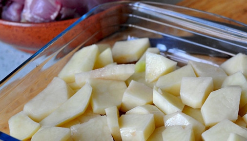 1. Этап. Куриные ножки с картошкой: Нарежьте картофель крупными кусочками, выложите его на дно формы для запекания.