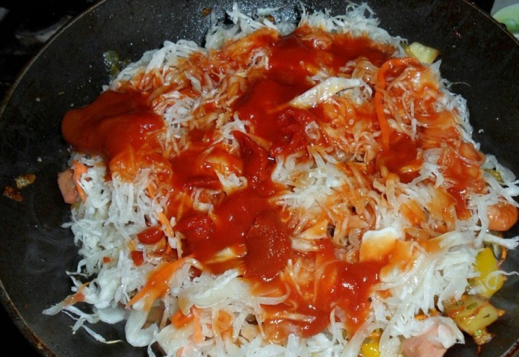 1. Этап. Бигус с грибами: По истечении времени добавляем нарезанные кружочками сосиски и измельченный чеснок, жарим все пару минут, после чего выкладываем на сковороду квашеную капусту (ее следует предварительно отжать) и томатную пасту. Вливаем на сковороду немного бульона, солим и перчим по вкусу, перемешиваем все и ставим на медленный огонь. Тушим бигус в течение часа, периодически помешивая его и доливая в блюдо бульон.