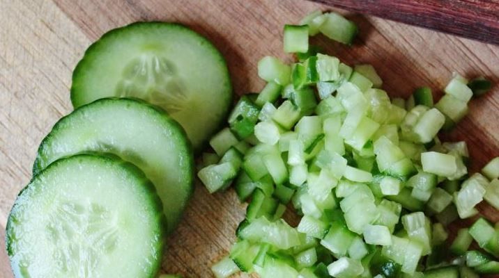 1. Этап. Интересный салат на день рождения: Огурцы вымойте и обсушите. Обрежьте с обеих сторон кончики. По желанию вы можете очистить огурцы от кожицы. Нарежьте их на кубики такой же величины, как и перец и хурму.