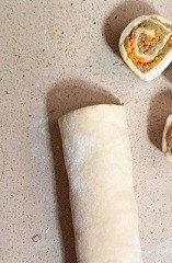 1. Этап. Ленивые пельмени в томатно-сметанном соусе: Плотно свернуть в рулет, разрезать на роллы толщиной около 2 см.