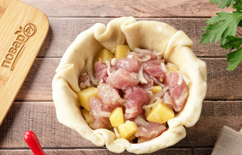 1. Этап. Жаркое в горшочке из теста: Начинку разделите так же на равные части и одну часть положите в чашку с тестом.