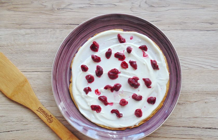 1. Этап. Медовик с вишней и сметанным кремом: На первый и третий корж выложите вишню без косточек. Можно добавить больше вишни, но это дело вкуса.