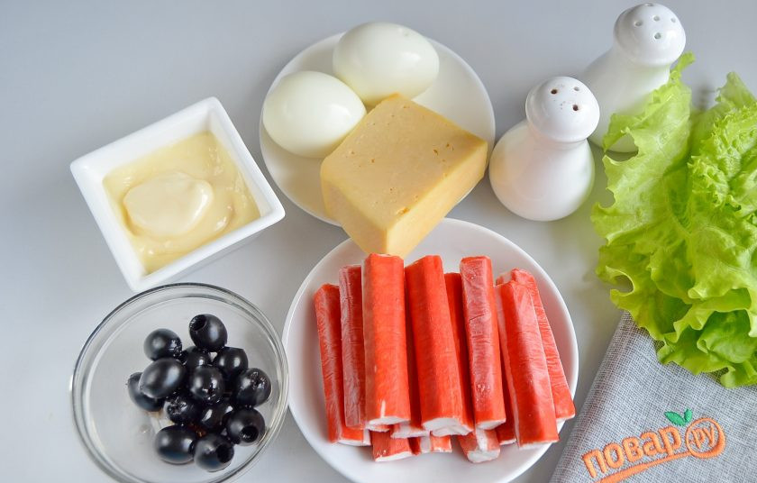 1. Этап. Салат-закуска Ёлочные шарики: Итак, подготовьте продукты. Отварите яйца, остудите и очистите от скорлупы. Крабовые палочки освободите от целлофановых пакетиков. Оливки отцедите от жидкости.