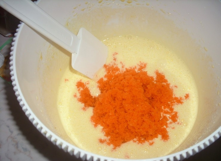 1. Этап. Простые морковные кексики: 4. В яичную смесь добавьте морковь, молоко, муку с разрыхлителем и хорошо перемешайте движениями снизу вверх.