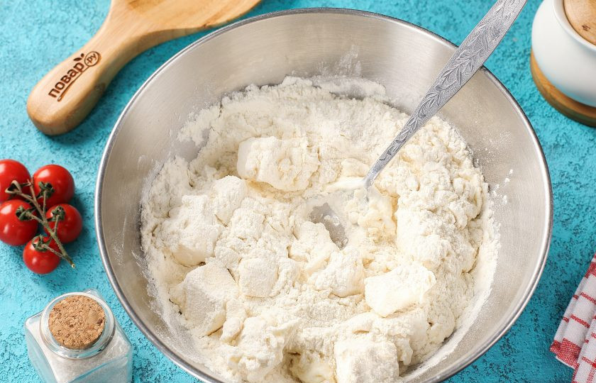 1. Этап. Песочное тесто на маргарине для пирога: Сначала перемешайте всё ложкой, а затем продолжите замес руками. Вымешивайте тесто до тех пор, пока оно не соберётся в комок.