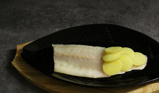 1. Этап. Филе сибаса под чешуёй из картофеля: Филе кладем в емкость для запекания кожей вниз, предварительно смазываем кожу растительным маслом и добавляем приправы по вкусу (у меня только соль и молотый перец). Начинаем выкладывать картофель, имитируя чешую.