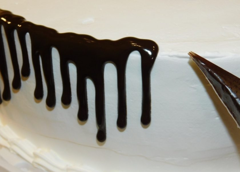 1. Этап. Торт с подтеками: Налейте глазурь в кондитерский мешок и отрежьте кончик. По краю торта делайте небольшие шоколадные подтеки.