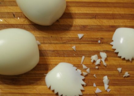 1. Этап. Салат Лебединая верность: Сначала сделаем лебедей. Из двух вареных яиц срезаем небольшую полоску белка, делаем хвосты для птиц. Яйца откладываем в сторонку.