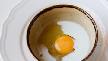 1. Этап. Слоеные палочки с сыром: К молоку добавить яйцо.