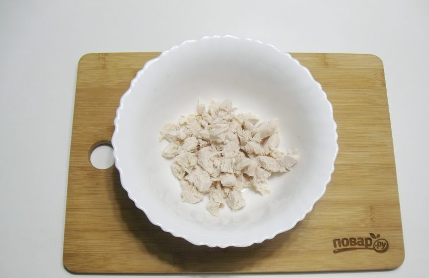 1. Этап. Салат Русская метель: Куриную грудку мелко нарежьте и выложите в салатник.