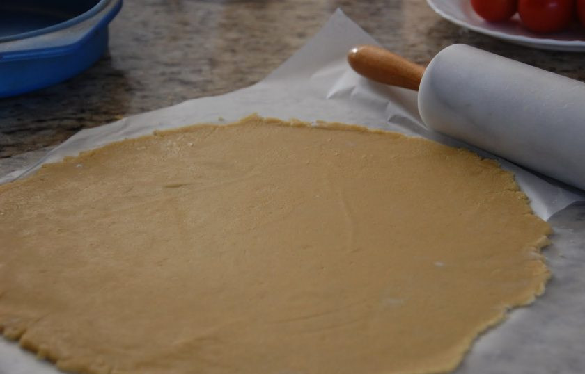 1. Этап. Тосканский чизкейк: 4. Разделите тесто на 2 части, одну уберите в морозилку, она не нужна. Оставшуюся раскатайте между 2 листами пергамента в тонкий пласт по форме для выпекания.