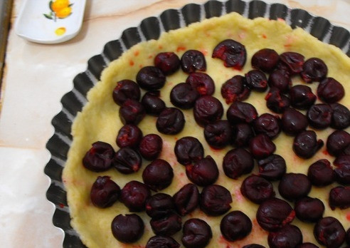 1. Этап. Заливной пирог с вишней: Возьмите форму для выпечки, распределите по ней тесто. Потом разложите на тесто ягоды, залейте все сливочной массой.