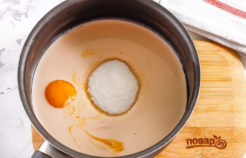 1. Этап. Крем из ряженки: Ряженку любой жирности перелейте в ковш или в казан с антипригарным дном. Разбейте куриные яйца и отделите белки от желтков. Желтки выложите в ряженку, белки используйте для другого рецепта. Всыпьте сахарный песок и влейте лимонный сок. Тщательно перемешайте всю массу венчиком.