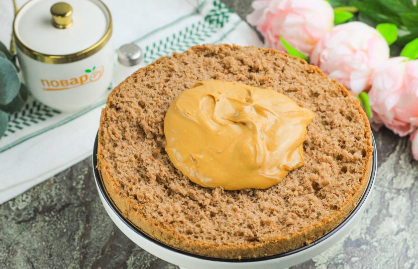 1. Этап. Шоколадный торт с кремом из вареной сгущенки: Выложите нижний корж на тарелку и обмажьте его кремом.