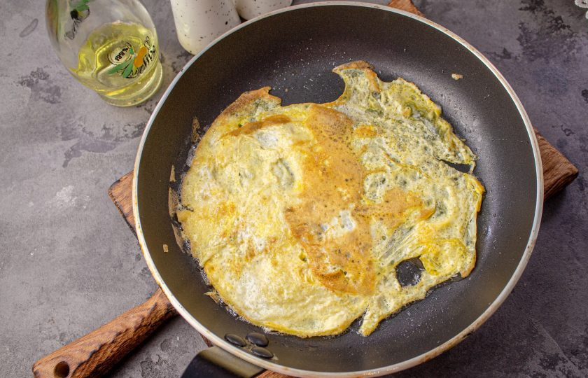 1. Этап. Салат с яичными блинчиками, копчёной курицей и кукурузой: Сковороду смажьте (для одного блина) чайной ложкой растительного масла, разогрейте ее и вылейте яйцо, формируя блинчик. Обжаривайте с двух сторон на среднем нагреве по минуте с одной стороны и 30 секунд со второй. Таким образом обжарьте 2 яичных блина, переложите их на разделочную доску, дайте немного остыть.