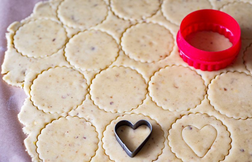 1. Этап. Австрийское Линцерское печенье: Затем охлажденное тесто раскатайте скалкой на рабочей поверхности в пласт толщиной примерно в 2 мм. Вырубите круглой формочкой четное количество кружочков (диаметр 5-7 см.). В половине кружочков из теста вырубите дополнительно выемки – у меня такие выемки в форме сердечек.