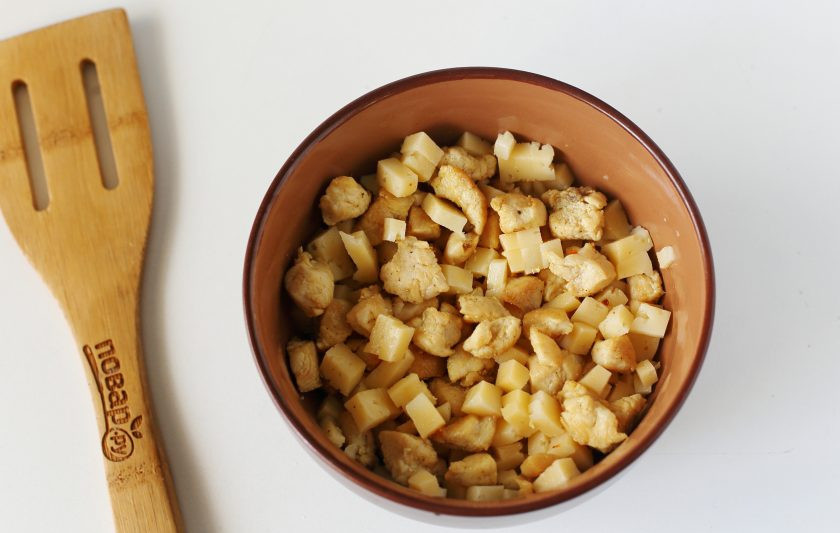 1. Этап. Булочки с курицей и сыром: Для начинки нарежьте куриное филе небольшими кубиками и обжарьте с солью и специями в сковороде. Охладите и добавьте нарезанный кубиками сыр.