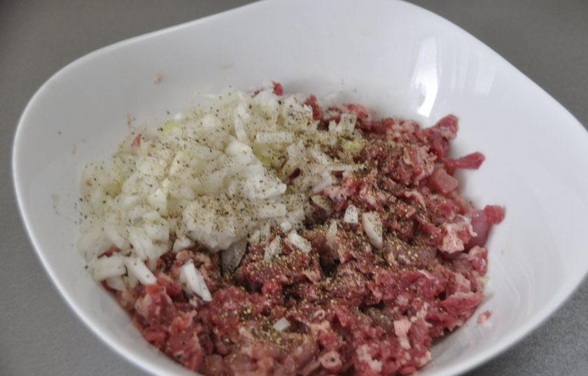 1. Этап. Кибинай: Нарежьте лук и мясо мелкими кусочками, именно нарежьте, а не перекрутите в мясорубке, от этого зависит вкус пирожков. Посолите, поперчите, добавьте пару столовых ложек ледяной воды, хорошо промешайте, как бы отбивая мясо.