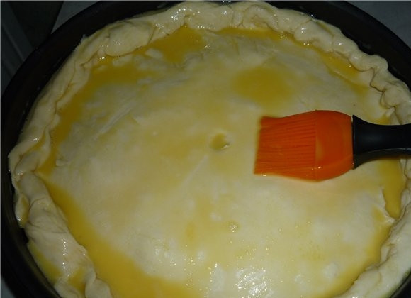 1. Этап. Пирог с мясом из слоеного бездрожжевого теста: Накрываем второй частью теста, защипываем края и смазываем пирог взбитым яйцом. Сделайте небольшую дырочку в центре пирога или небольшие разрезы по всему пирогу.