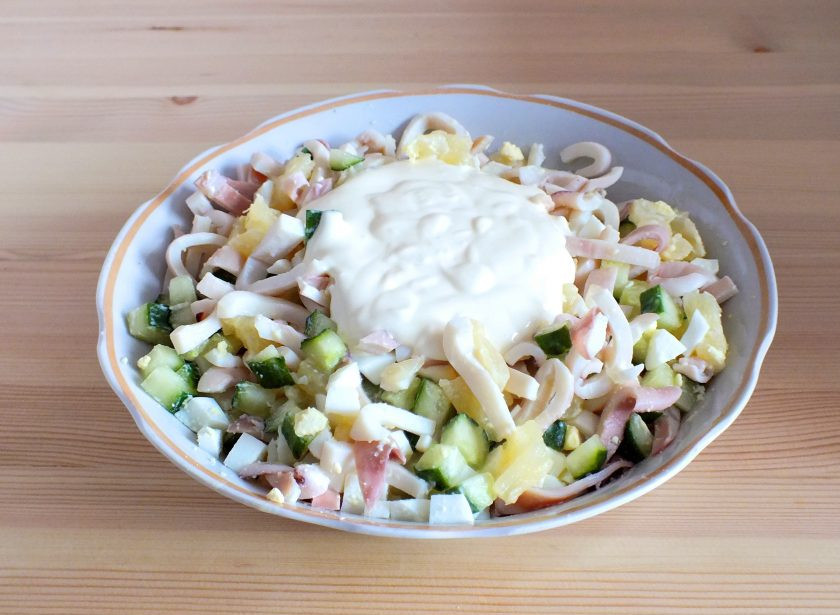 1. Этап. Салат из кальмаров, ананасов и огурцов: В салатник добавьте нарезанные кальмары, заправку.