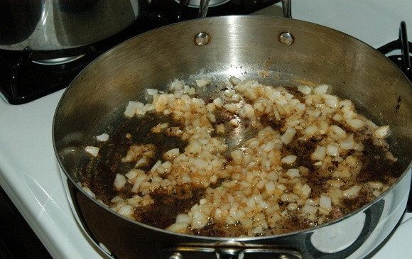 1. Этап. Бефстроганов с грибами и луком: Посыпьте в сковороду для соуса мелко нарезанный лук.