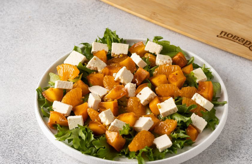 1. Этап. Оранжевый салат с мандаринами и хурмой: Сверху выложите сыр и полейте заправкой.