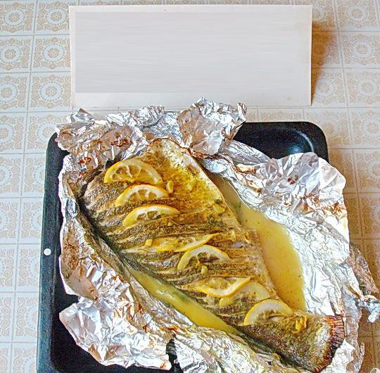 1. Этап. Запеченный толстолоб с лимоном и зеленью: 5. Запекаем рыбу в духовке приблизительно минут тридцать-сорок. После оставляем ее там еще минут на пятнадцать, для того, чтобы рыба была сочней. Теперь фольгу снимаем и рыбу перекладываем на тарелку.
