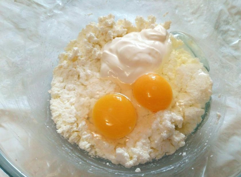 1. Этап. Творожные пышки: Добавьте в творог сметану и вбейте яйца, соедините ингредиенты в однородную массу.