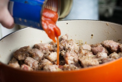 1. Этап. Свинина с фасолью и помидорами: 4. Приготовьте бульон - разогрейте его. Если готового бульона нет, залейте кубик кипятком. К бекону и луку верните свинину, перемешайте, добавьте помидоры.