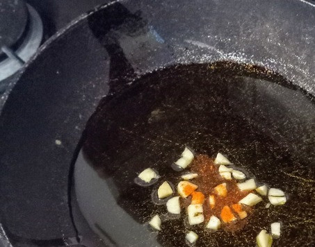 1. Этап. Зелень в сливочном соусе с кочудяном: В большой сковороде на сильном огне растопите масло. Положите чеснок и красный перец. Жарьте минуту до появления аромата.